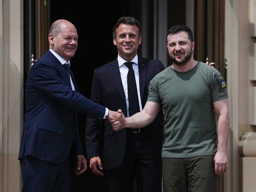 Wolodymyr Selenskyj (r), Präsident der Ukraine, begrüßt Bundeskanzler Olaf Scholz (l, SPD) und Emmanuel Macron (M), Präsident von Frankreich. 