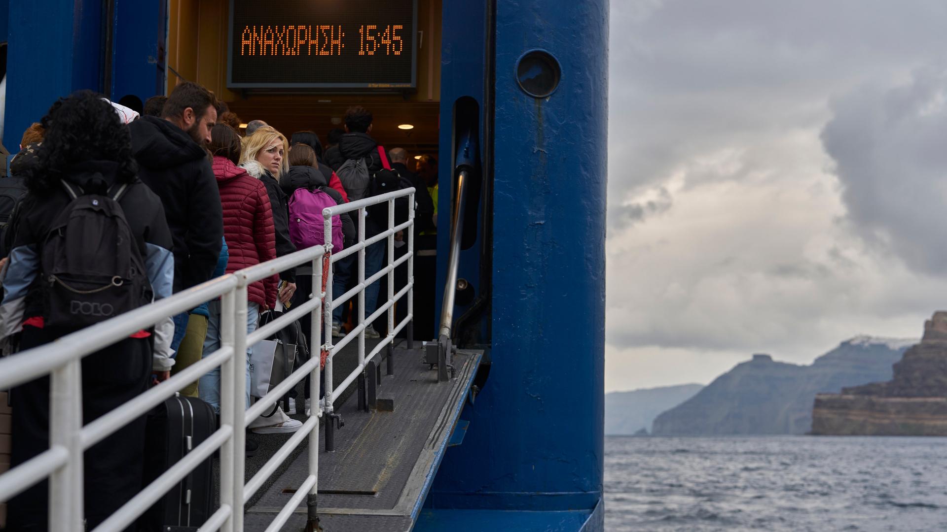 Menschen gehen an Bord der Fähre, um Santorini zu verlassen.