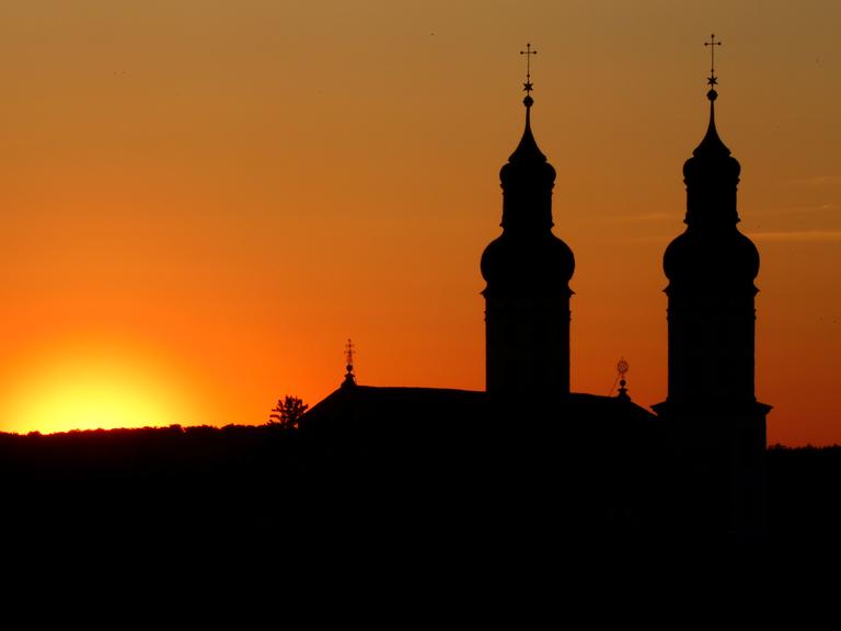 Neben den Türmen am Münster "Sankt Peter und Paul" in geht am Morgen die Sonne auf.