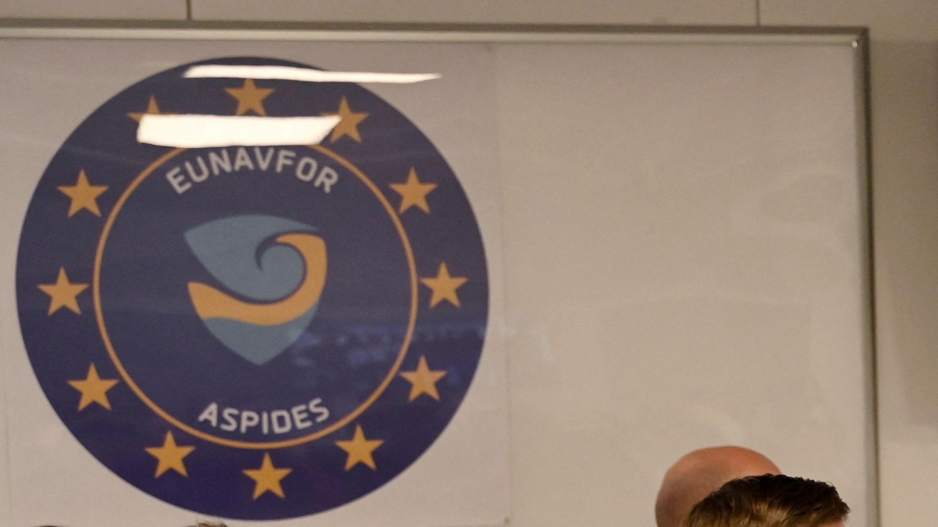 Das Logo des EU-Einsatzes "Aspides", ein blauer Kreis mit gelben Sternen, darin steht "EUNAVFOR" und "ASPIDES". Das Logo des EU-Einsatzes "Aspides", ein blauer Kreis mit gelben Sternen, darin steht "EUNAVFOR" und "ASPIDES".