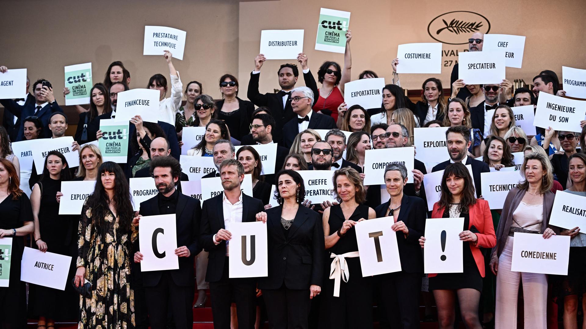 Etliche Gründungsmitglieder der Initiative CUT! halten auf dem roten Teppich in Cannes Plakate in die Höhe. Etliche Gründungsmitglieder der Initiative CUT! halten auf dem roten Teppich in Cannes Plakate in die Höhe.