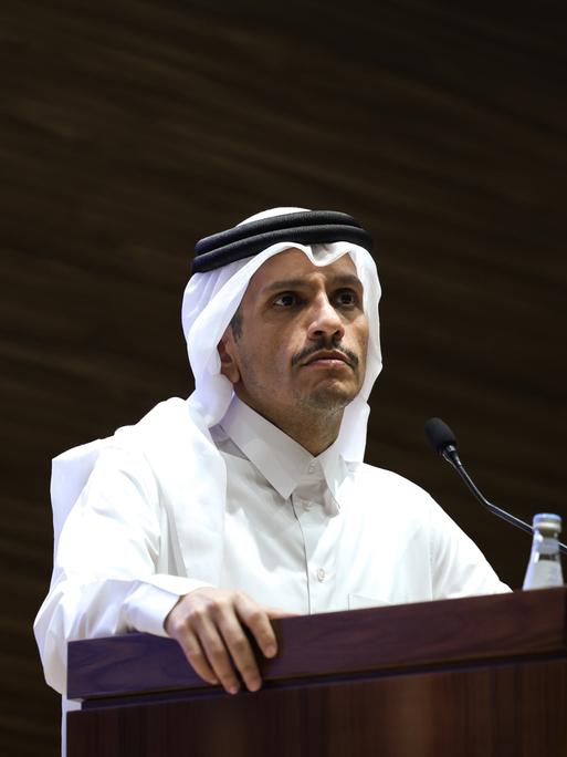 Der katarische Ministerpräsident Mohammed Bin Abdulrahman Al Thani steht an einem Pult, an dem ein Mikrofon steht. 