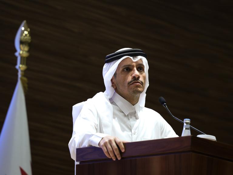 Der katarische Ministerpräsident Mohammed Bin Abdulrahman Al Thani steht an einem Pult, an dem ein Mikrofon steht. 