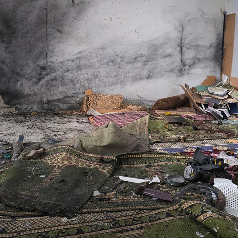 Verwüstungen in der Imam-Ali-bin-Abi-Talib-Moschee nach dem Anschlag: Gebetsteppiche und weitere religiöse Utensilien liegen zerstört und zerstreut auf dem Boden, die rußgeschwärzte Wand im Hintergrund ist durchbrochen(Photo by HANDOUT / SANA / AFP) / RESTRICTED TO EDITORIAL USE - MANDATORY CREDIT "AFP PHOTO / SANA " - HANDOUT - NO MARKETING NO ADVERTISING CAMPAIGNS - DISTRIBUTED AS A SERVICE TO CLIENTS