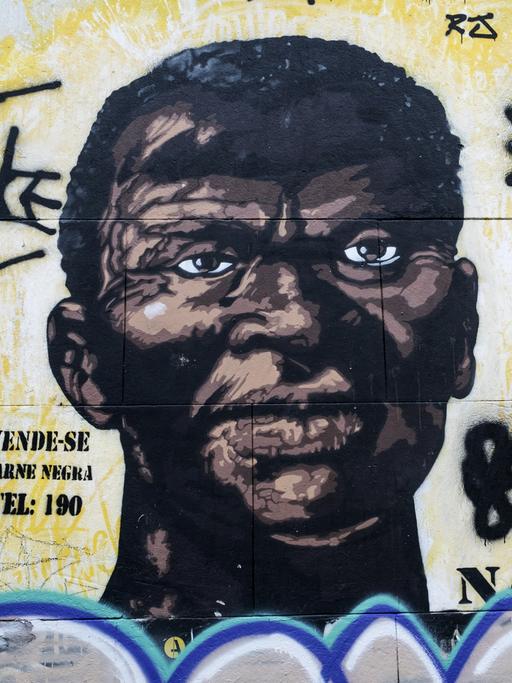 "Man verkauft - Schwarzes Fleisch - Tel: 190" steht neben der Wandmalerei eines großen Männerporträts im ehemaligen Sklavenviertel an der Pedra do Sal in Rio de Janeiro. 