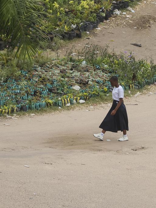 Eine Frau geht in Kinshasa in der Demokratischen Republik Kongo eine Straße entlang.