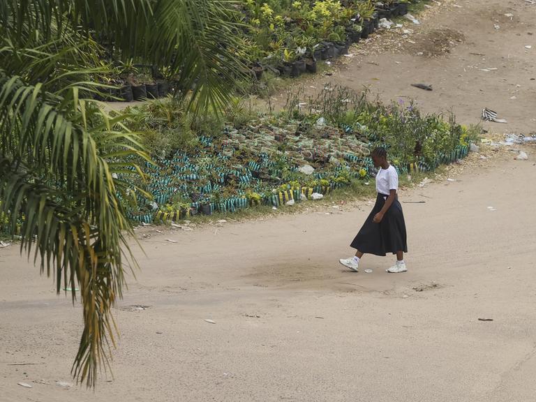 Eine Frau geht in Kinshasa in der Demokratischen Republik Kongo eine Straße entlang.