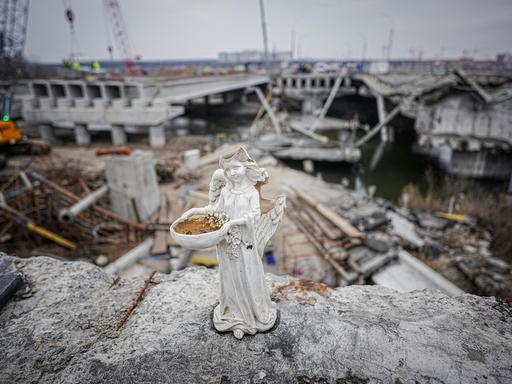 Ein kaputter Engel steht auf der im Krieg zerstörten Brücke auf der Ausfallstraße von Irpin in der Nähe von Kiew. Der Wiederaufbau der Brücke ist in vollem Gange.