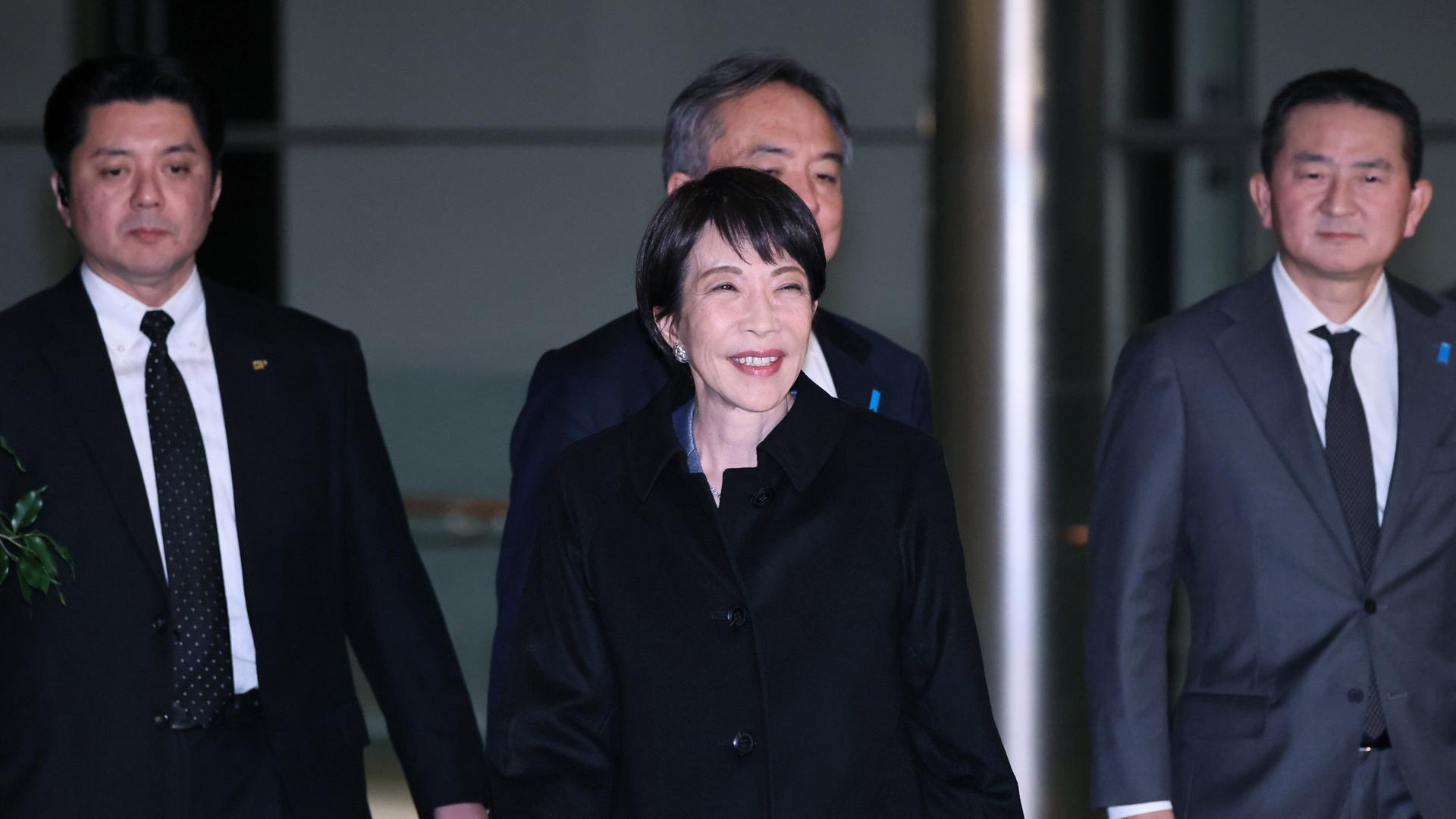 Die japanische Premierministerin Sanae Takaichi verlässt das Amtssitz des Premierministers in Tokio. Hinter ihr gegen mehrere Personen. 