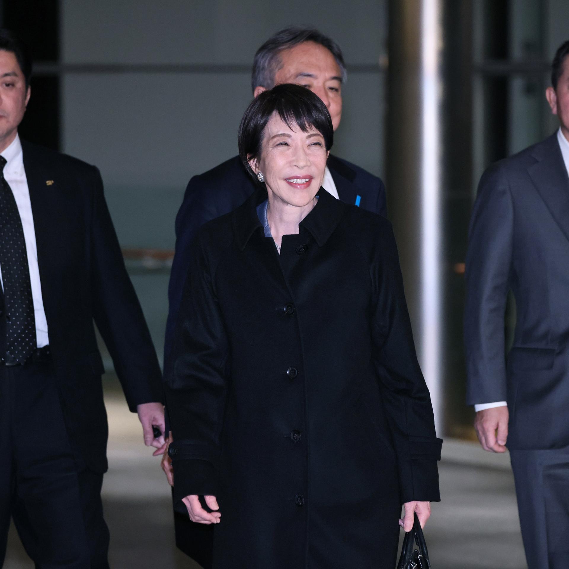 Die japanische Premierministerin Sanae Takaichi verlässt das Amtssitz des Premierministers in Tokio. Hinter ihr gegen mehrere Personen. 