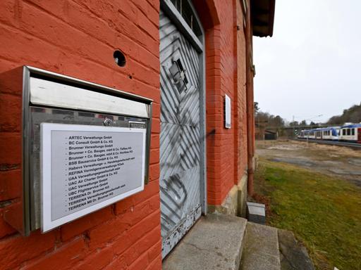 Am Briefkasten eines maroden Gebäudes am Bahnhof ist eine lange Liste von Firmen aufgelistet.