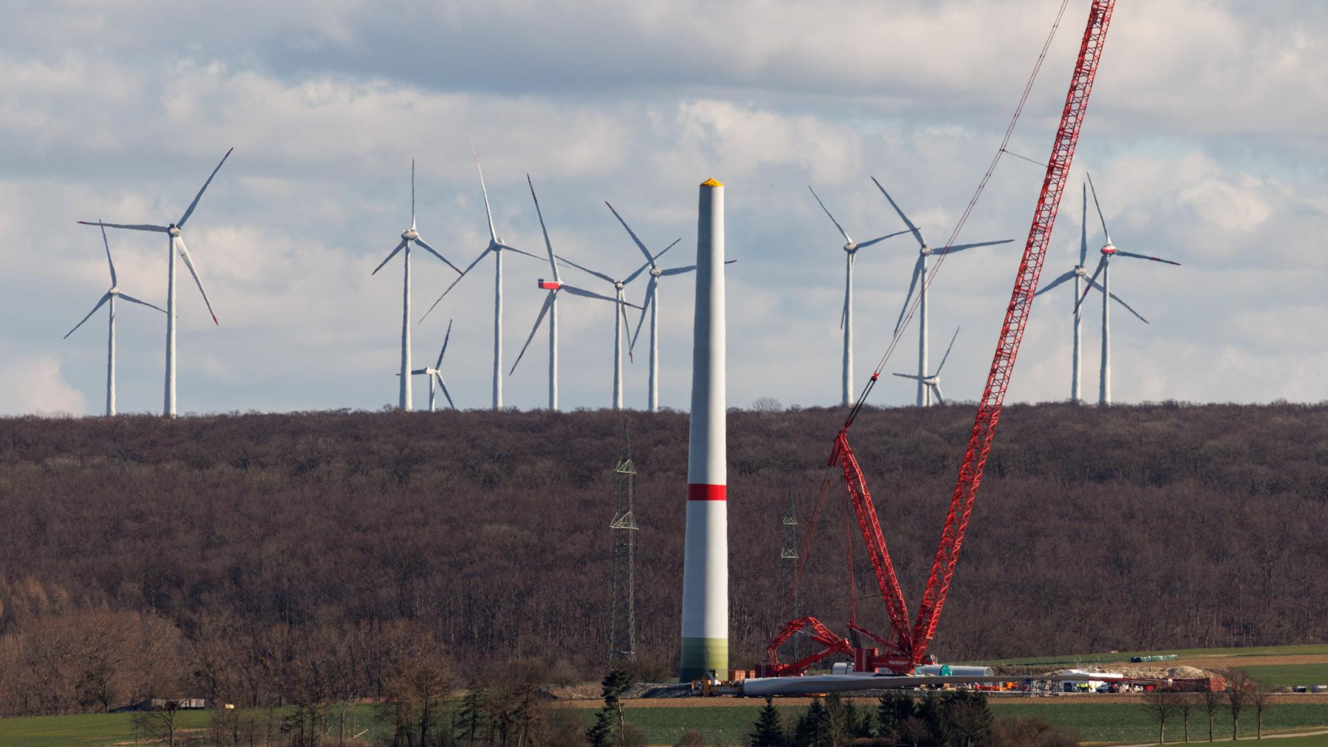 Zahlreiche Windkraftanlagen sind am 17.03.2025 in einem Windpark bei Borchen Etteln (Nordrhein-Westfalen) zu sehen, während im Vordergrund eine neue Windkraftanlage aufgebaut wird. Zahlreiche Windkraftanlagen sind am 17.03.2025 in einem Windpark bei Borchen Etteln (Nordrhein-Westfalen) zu sehen, während im Vordergrund eine neue Windkraftanlage aufgebaut wird.
