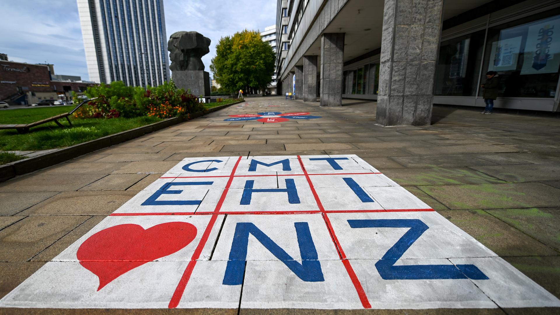 Die Buchstaben für Chemnitz stehen in einer Matrix auf dem Fußweg hinter dem Karl-Marx-Monument.