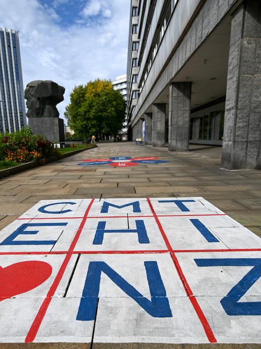 Die Buchstaben für Chemnitz stehen in einer Matrix auf dem Fußweg hinter dem Karl-Marx-Monument.
