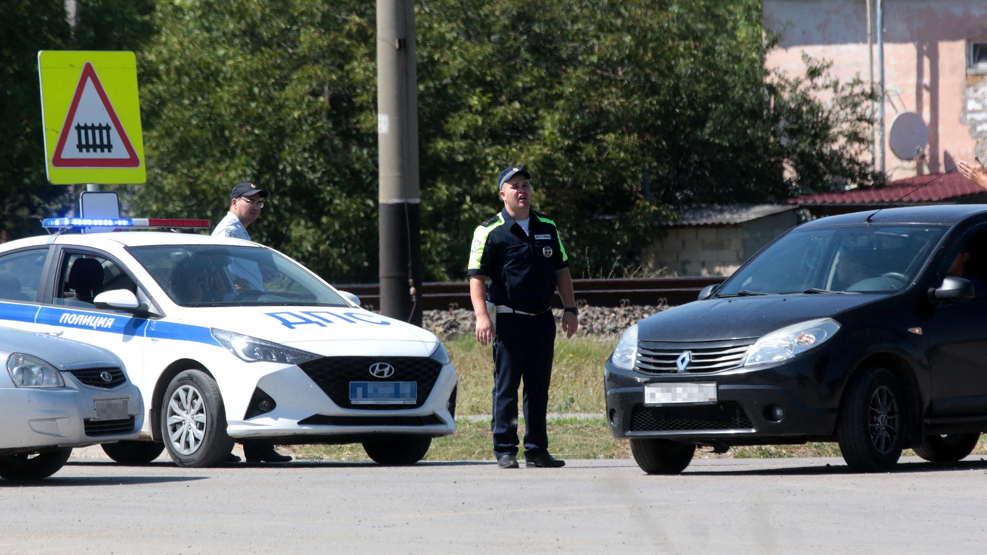 Verkehrspolizisten blockieren wegen der Evakuierung nahe Simferopol eine Straße. Auf der Krim ist nach ukrainischem Beschuss in ein Munitionsdepot explodiert. Verkehrspolizisten blockieren wegen der Evakuierung nahe Simferopol eine Straße. Auf der Krim ist nach ukrainischem Beschuss in ein Munitionsdepot explodiert.
