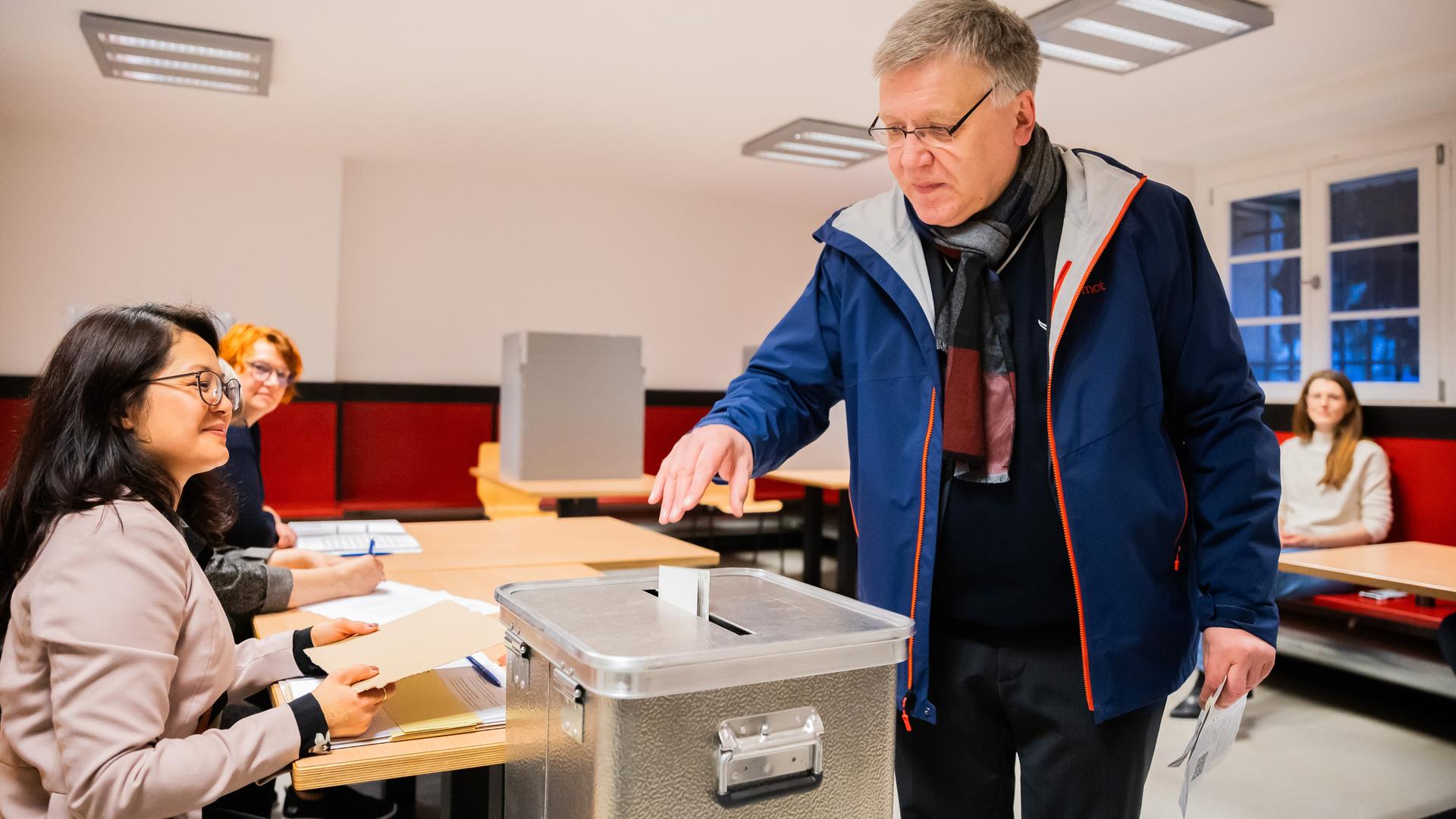 Stephan Bröchler (r), Landeswahlleiter für Berlin, wirft seinen Stimmzettel in eine Wahlurne.