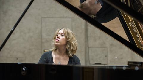 Wir sehen eine Frau, die Klavier spielt. 