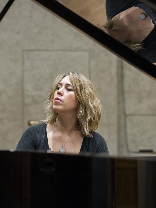 Wir sehen eine Frau, die Klavier spielt. 