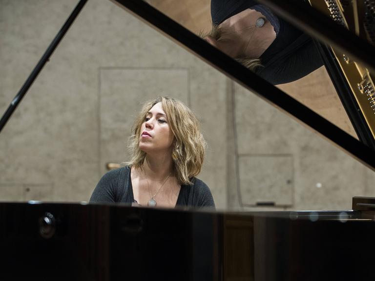 Wir sehen eine Frau, die Klavier spielt. 