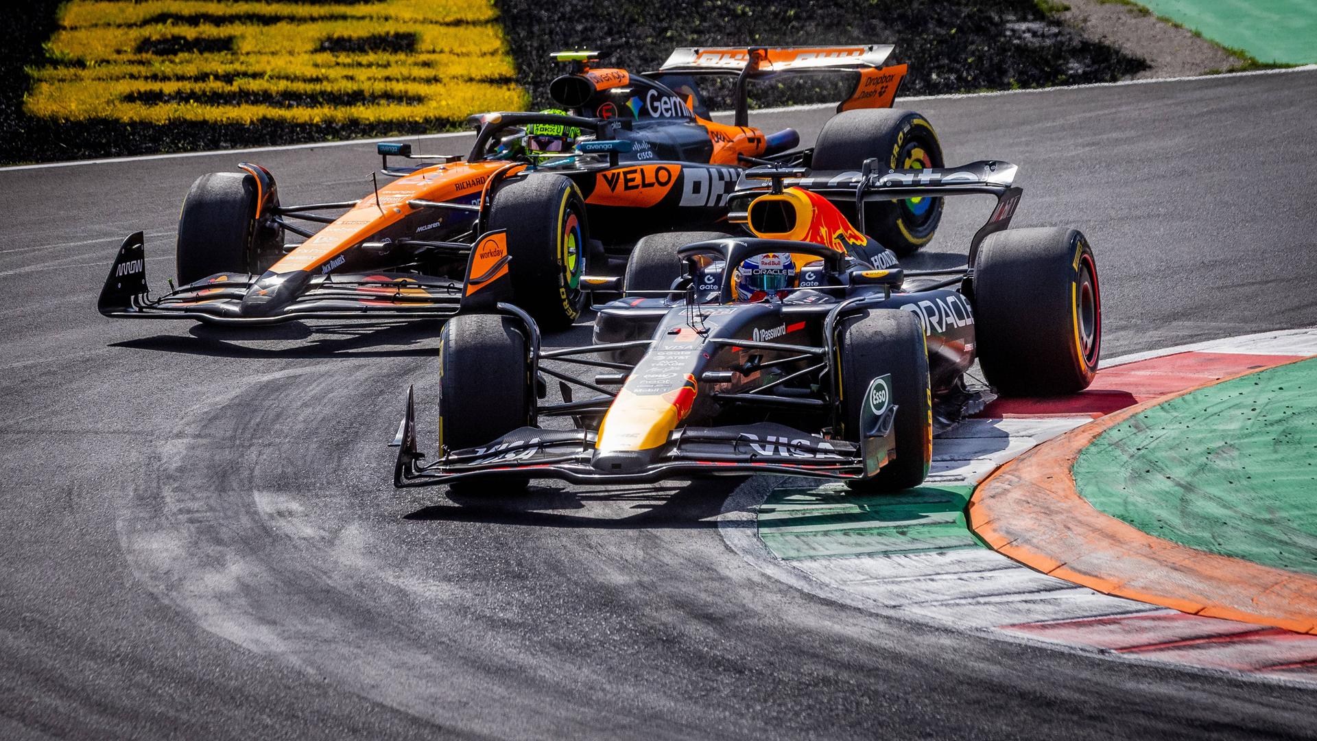 Formel-1-Fahrer Max Verstappen fährt mit seinem Rennwagen durch eine enge Kurve, hinter ihm fährt Lando Norris im McLaren-Auto. Formel-1-Fahrer Max Verstappen fährt mit seinem Rennwagen durch eine enge Kurve, hinter ihm fährt Lando Norris im McLaren-Auto.