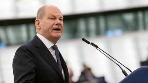 Scholz steht im Gebäude des Europäischen Parlaments und spricht in ein Mikrofon.