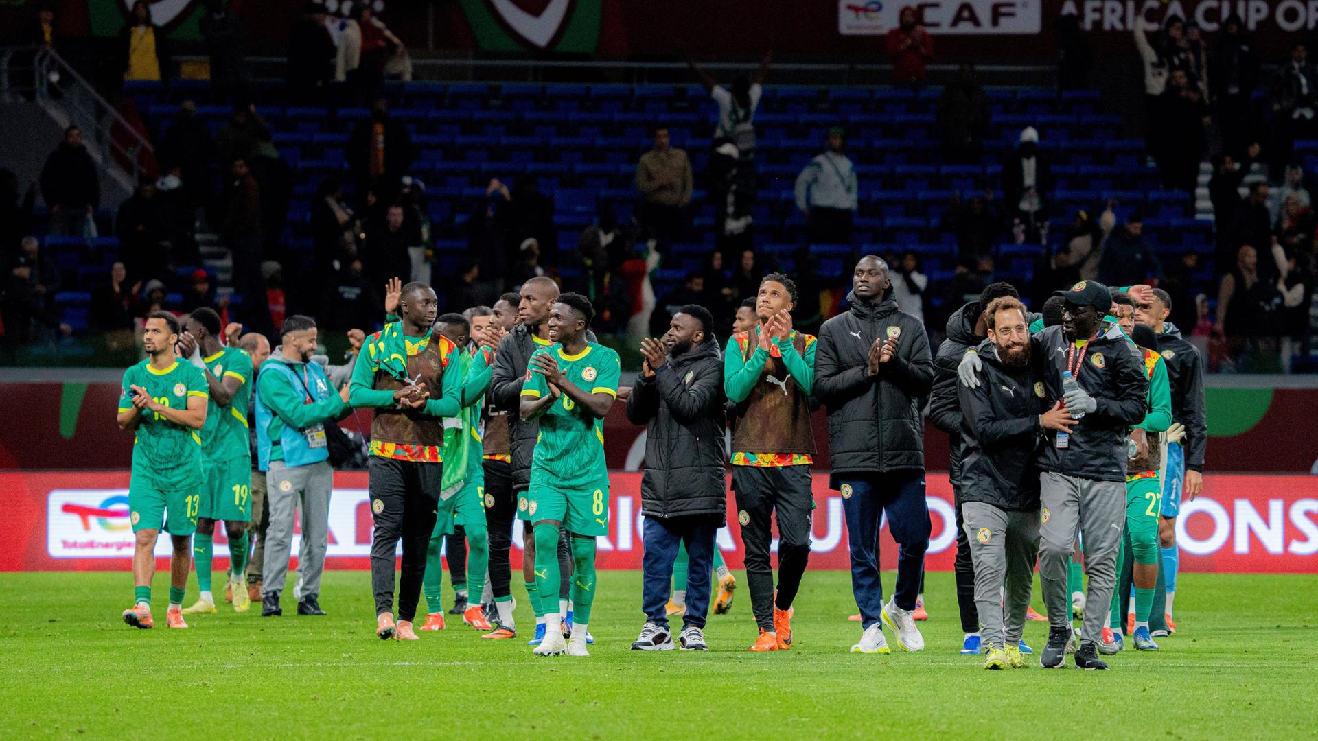 Die Spieler des Senegal laufen nach dem Spiel über den Platz und applaudieren.