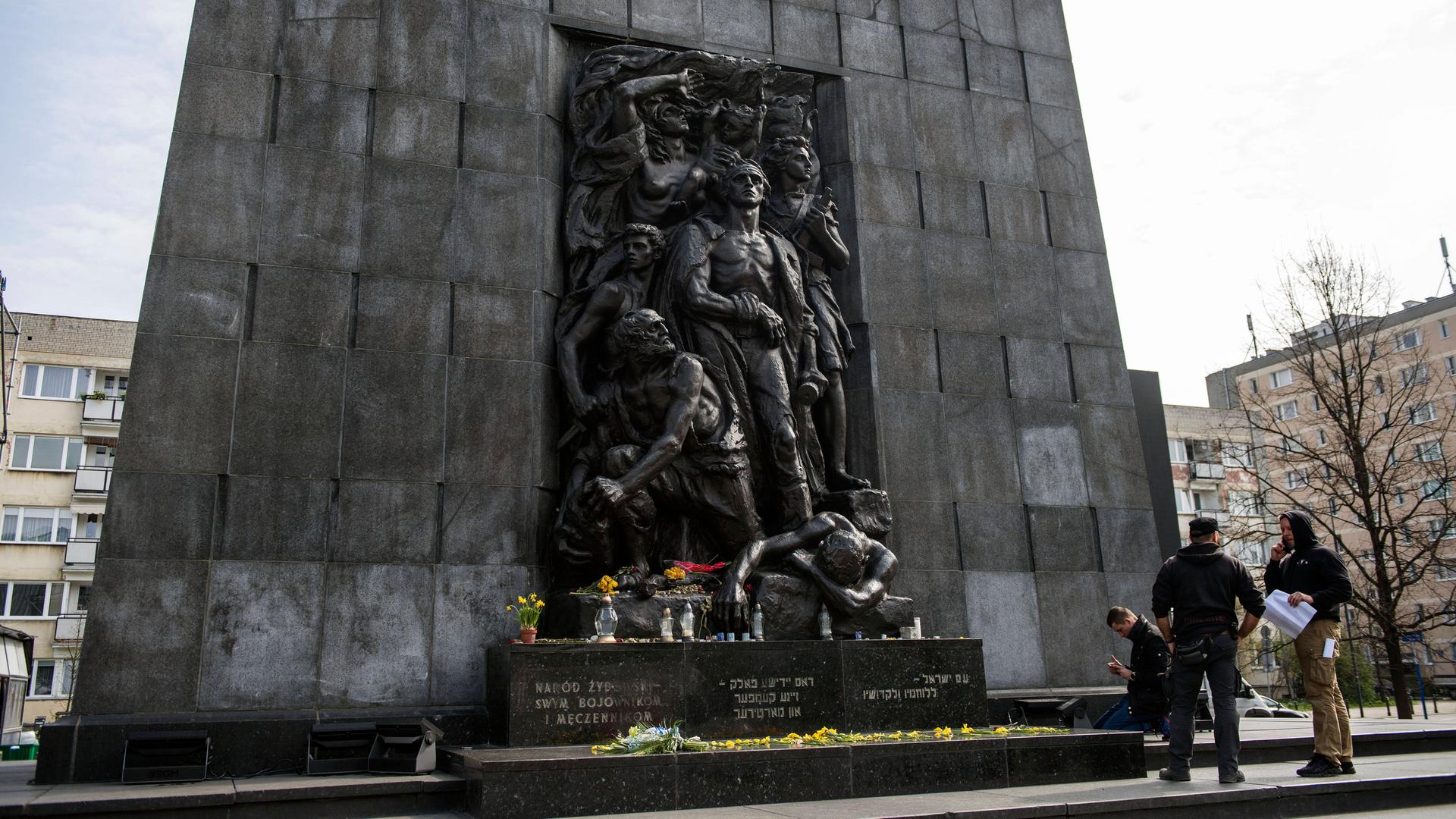 Menschen stehen vor dem Denkmal der Helden des Ghettos in Warschau, das zum Gedenken des Aufstands im Warschauer Ghetto 1943 errichtet wurde.