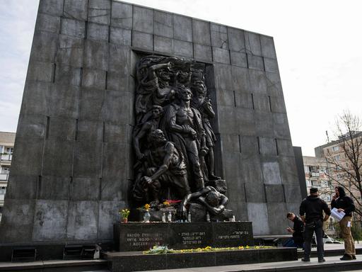 Menschen stehen vor dem Denkmal der Helden des Ghettos in Warschau, das zum Gedenken des Aufstands im Warschauer Ghetto 1943 errichtet wurde.