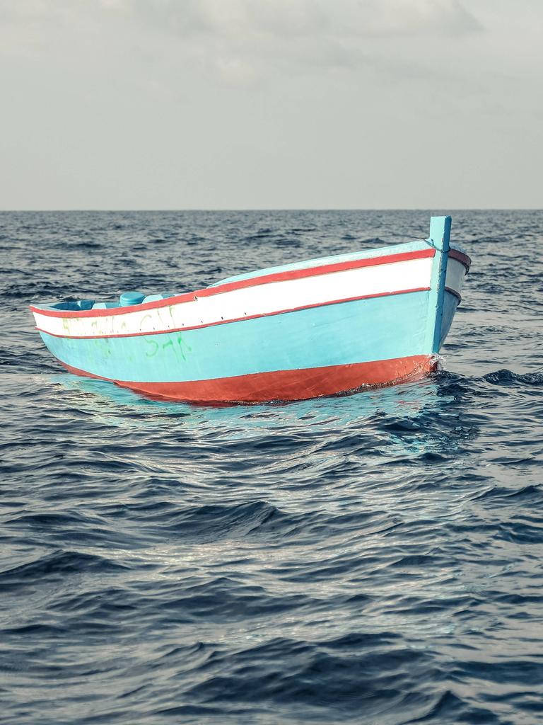 Ein leeres, türkises Flüchtlingsboot aus Holz treibt westlich von Tripolis in Internationalen Gewässern.