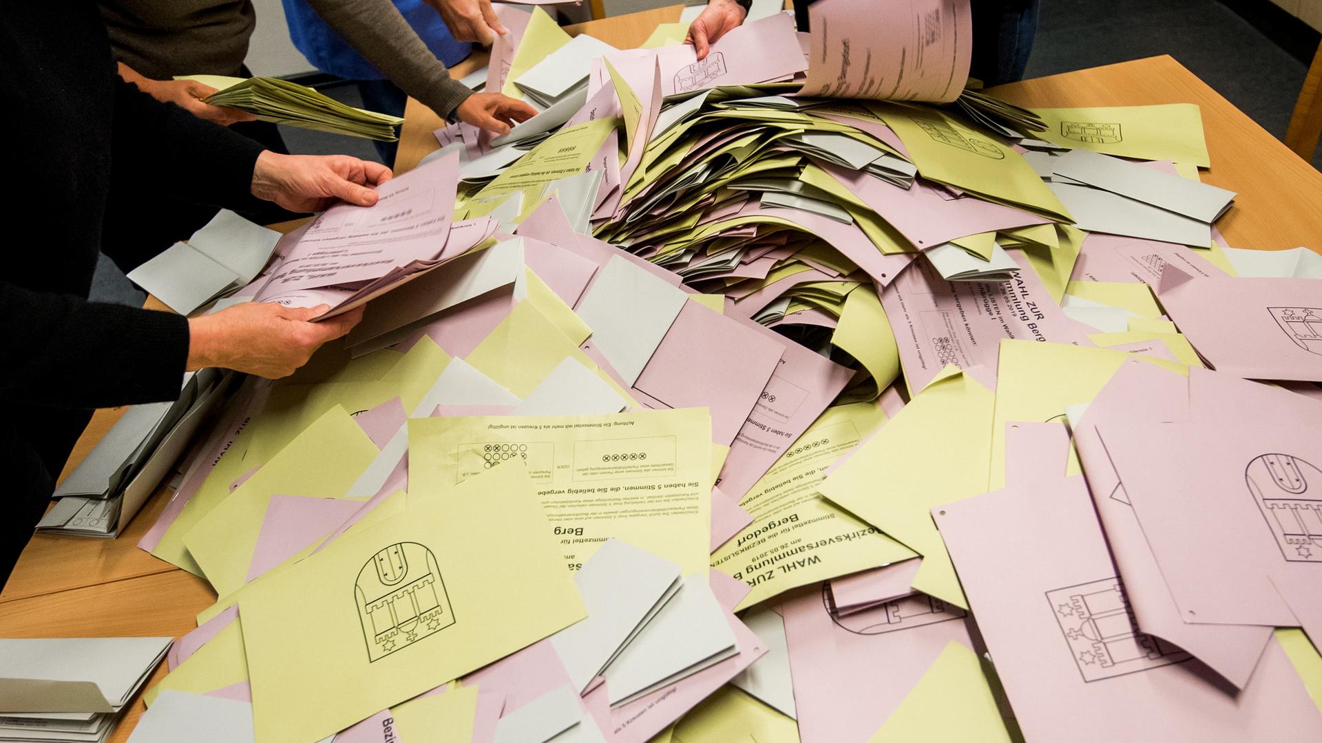 Zu sehen ist ein Haufen gelber und rosa Briefumschlägen mit Hamburger Stattwappen bei der Auszählung zur Europawahl und zur Bezirksversammlungswahl in Hamburg 2019 befinden.