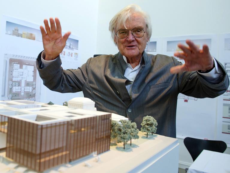 Der Architekt Meinhard von Gerkan erhebt die Hände wie ein Dirigent über einem Modell für dem Neubau der Kunsthalle Mannheim.