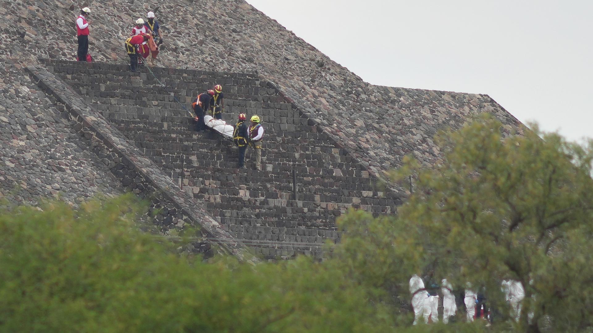 Mexiko, Teotihuacan: Gerichtsmediziner tragen die Leiche eines Opfers eine Pyramide hinunter.