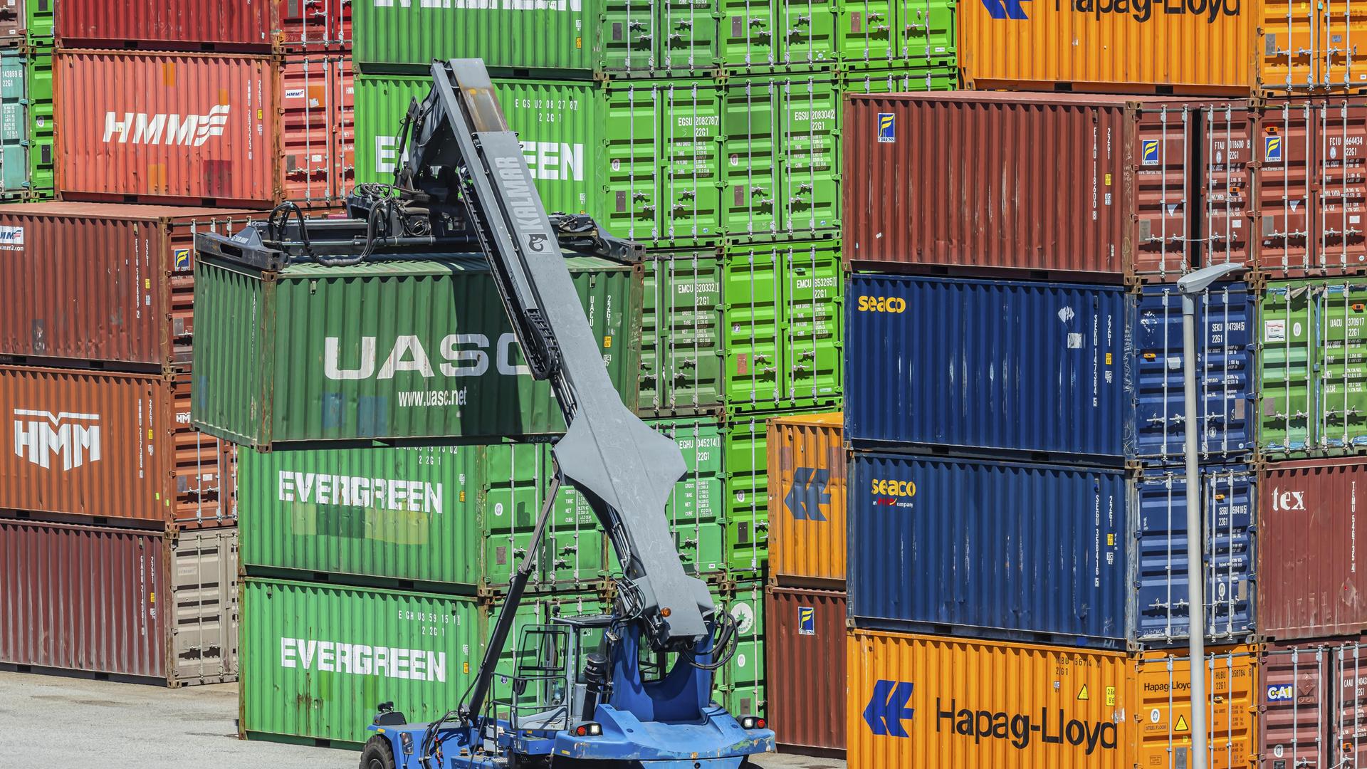 Bunte Frachtcontainer stapeln sich im Containerterminal. Kräne beladen und entladen Schiffe, Züge und Lkw. Bunte Frachtcontainer stapeln sich im Containerterminal. Kräne beladen und entladen Schiffe, Züge und Lkw.