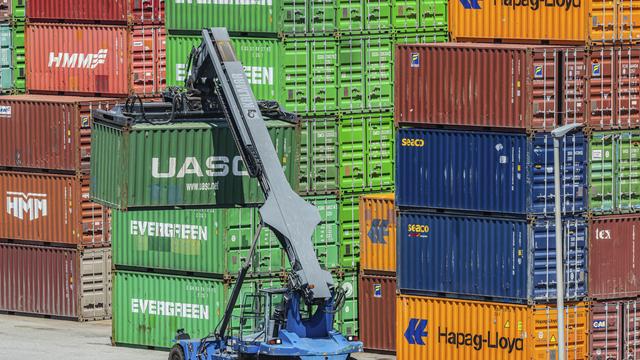 Bunte Frachtcontainer stapeln sich im Containerterminal. Kräne beladen und entladen Schiffe, Züge und Lkw. 