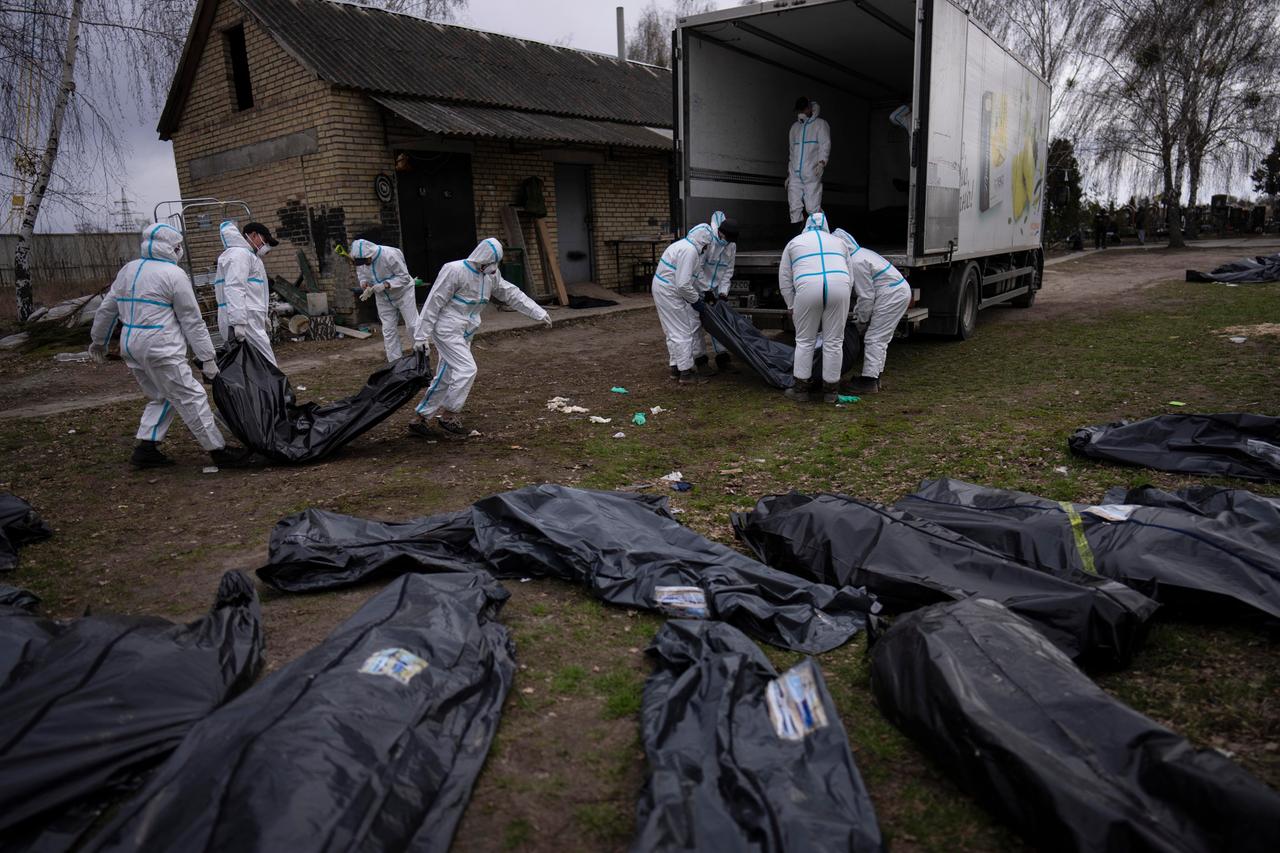 April 2022: Freiwillige laden die Leichen der in Butscha, einem Außenbezirk von Kiew, getöteten Zivilisten auf einen Lastwagen, um sie zur Untersuchung in ein Leichenschauhaus zu bringen. (Foto: Rodrigo Abd/AP/dpa)