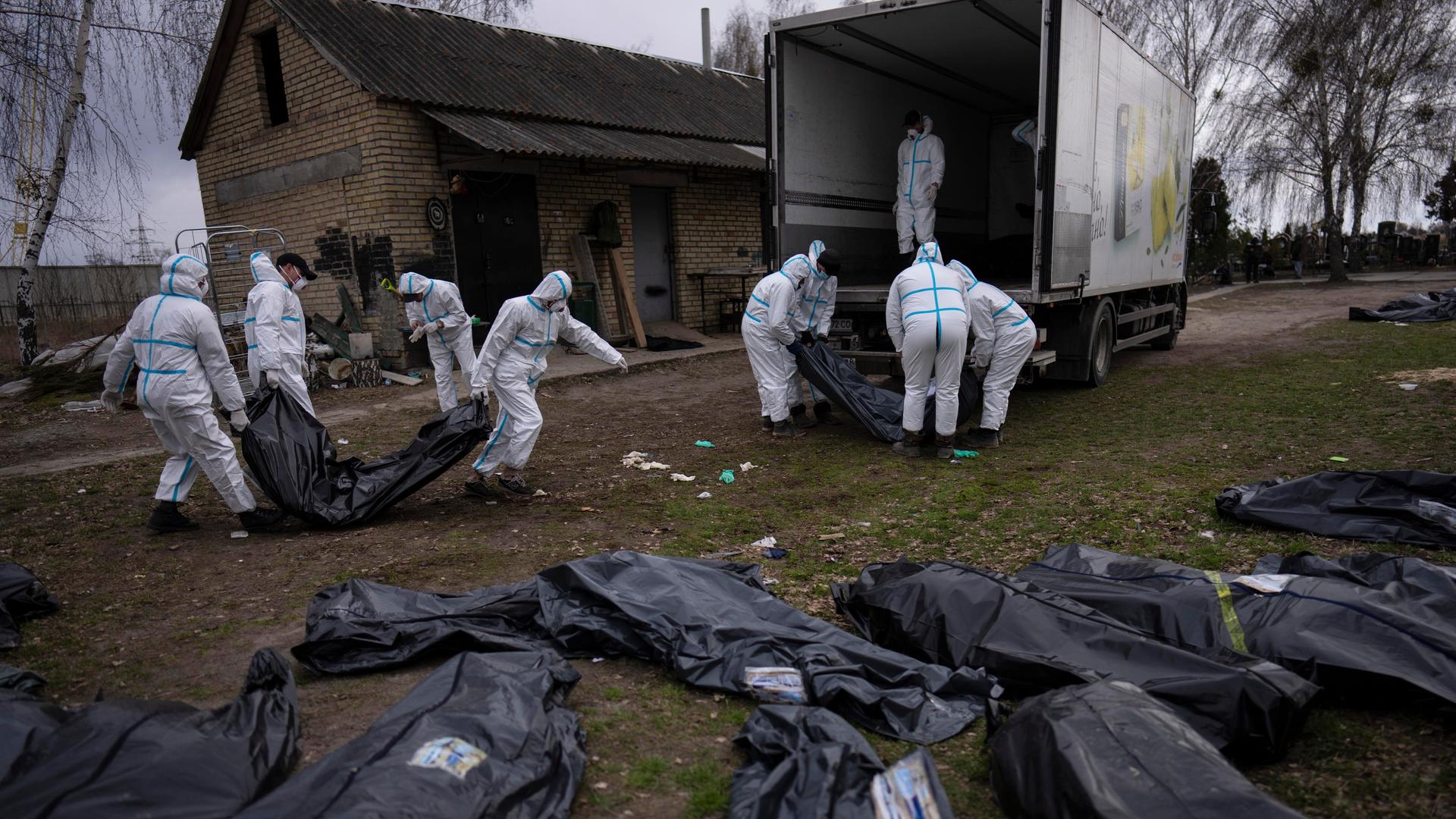 Freiwillige laden die Leichen der in Butscha, einem Außenbezirk von Kiew, getöteten Zivilisten auf einen Lastwagen, um sie zur Untersuchung in ein Leichenschauhaus zu bringen. Freiwillige laden die Leichen der in Butscha, einem Außenbezirk von Kiew, getöteten Zivilisten auf einen Lastwagen, um sie zur Untersuchung in ein Leichenschauhaus zu bringen.