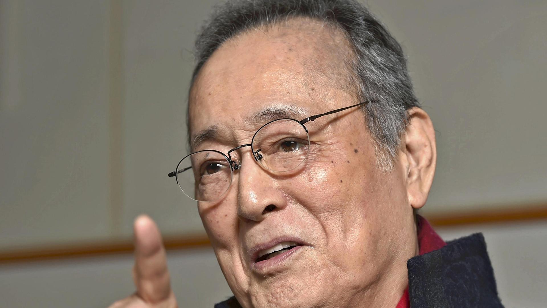 Der japanische Schauspieler Tatsuya Nakadai spricht während eines Interviews und gestikuliert mit der rechten Hand.