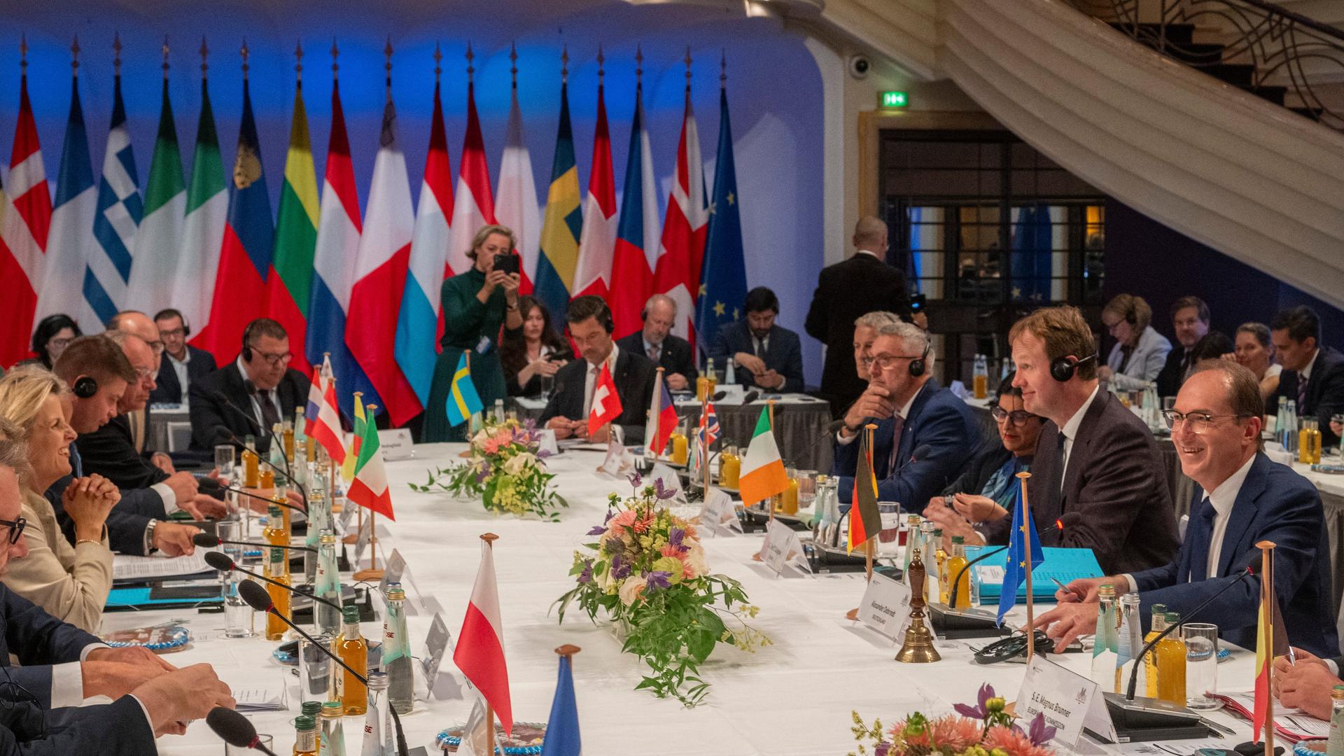 Europäische Innenminister tagen unter Leitung von Bundesminister Alexander Dobrindt (rechts im Bild) in München. Sie sitzen an einem großen Tisch, im Hintergrund sind mehrere Landesflaggen zu sehen. Europäische Innenminister tagen unter Leitung von Bundesminister Alexander Dobrindt (rechts im Bild) in München. Sie sitzen an einem großen Tisch, im Hintergrund sind mehrere Landesflaggen zu sehen.