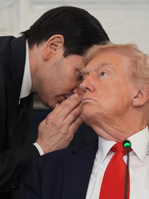 US-Außenminister Rubio flüstert US-Präsident Trump während einer Pressekonferenz etwas ins Ohr.
