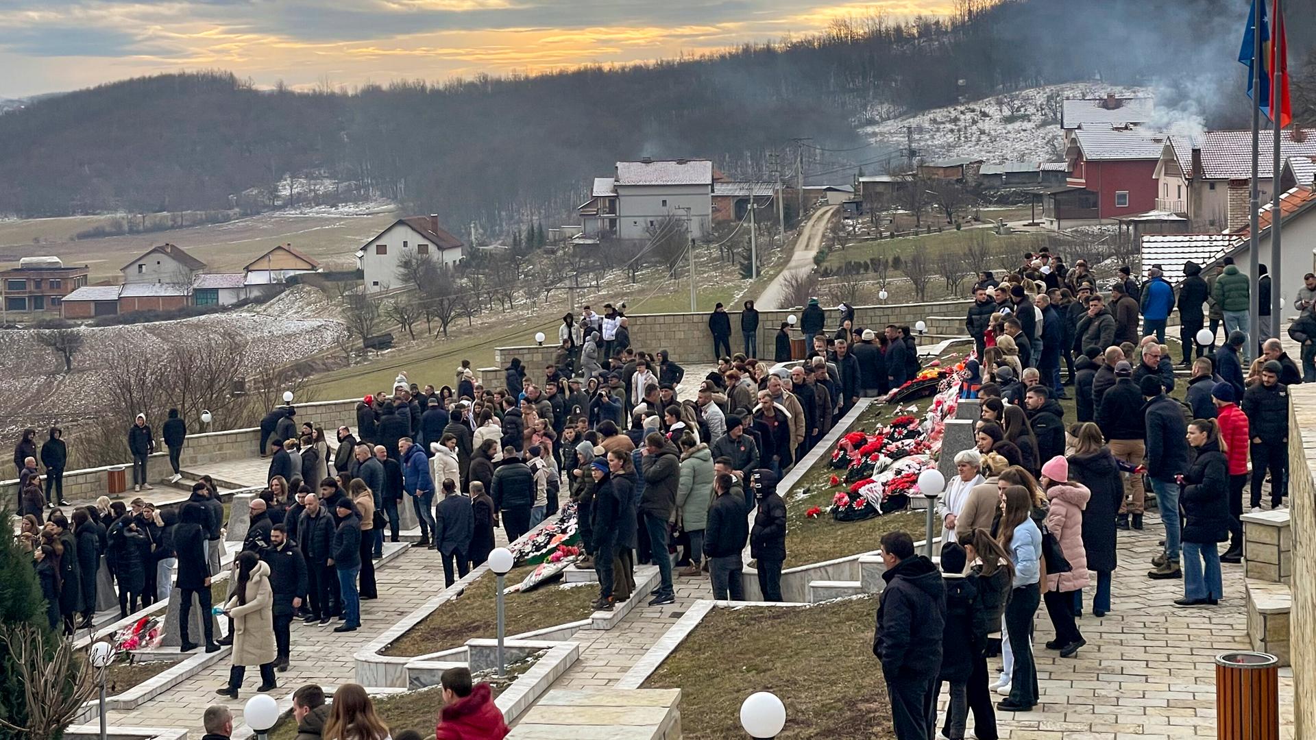 Menschen gehen am Montag, dem 15. Januar 2024, auf einem Friedhof während einer Gedenkveranstaltung für Kosovaren, die 1999 von serbischen Streitkräften in Rečak (Kosovo) getötet wurden. Menschen gehen am Montag, dem 15. Januar 2024, auf einem Friedhof während einer Gedenkveranstaltung für Kosovaren, die 1999 von serbischen Streitkräften in Rečak (Kosovo) getötet wurden.