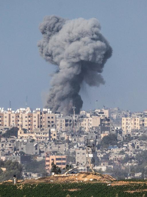Ein dunkle Rauchsäule steht über einer Siedlung: Im Kampf gegen die radikalislamische Terrororganisation Hamas bombardiert das israelische Militär Ziele im Gazastreifen