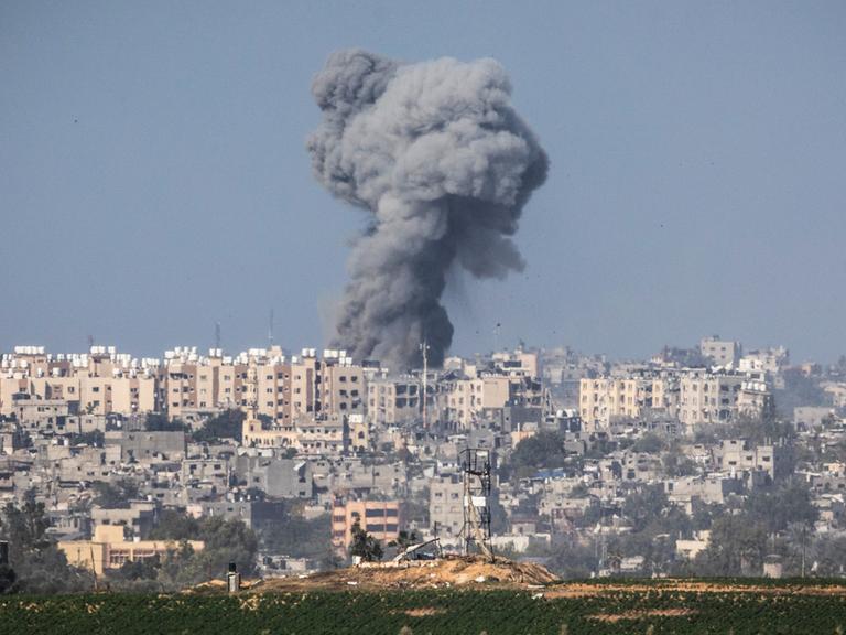 Ein dunkle Rauchsäule steht über einer Siedlung: Im Kampf gegen die radikalislamische Terrororganisation Hamas bombardiert das israelische Militär Ziele im Gazastreifen
