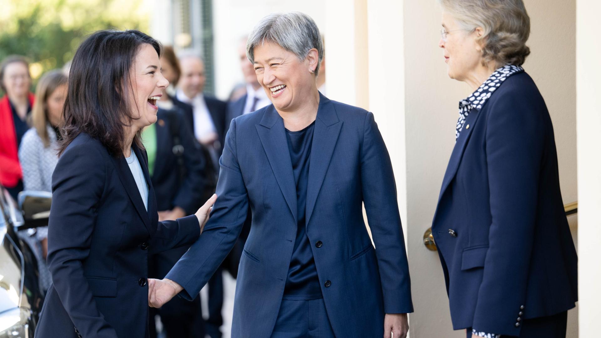 Annalena Baerbock und zwei weitere Frauen stehen beisammen, geben sich die Hand und lachen. Die beiden anderen Frauen sind Frances Adamson, Gouverneurin des Bundesstaates Südaustralien, und Penny Wong, Außenministerin von Australien.