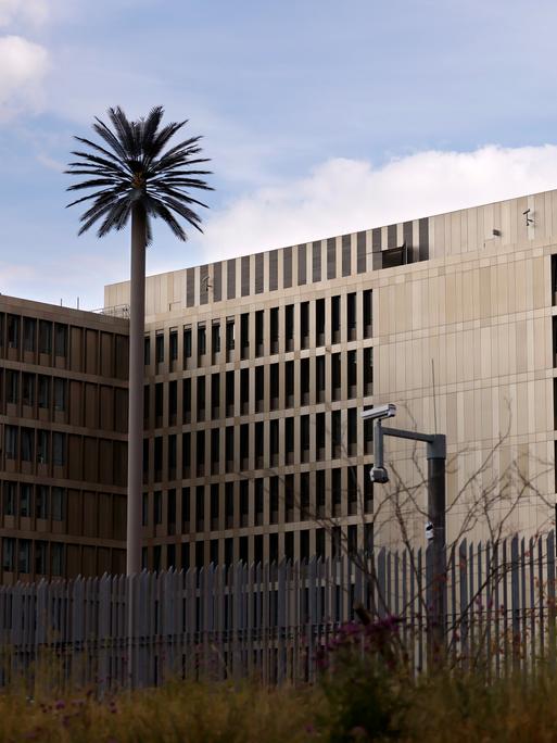Zu sehen ist der Hauptsitz des Bundesnachrichtendienst (BND) in Berlin. Zu sehen sind ein großer Zaun und eine Überwachungskamera.