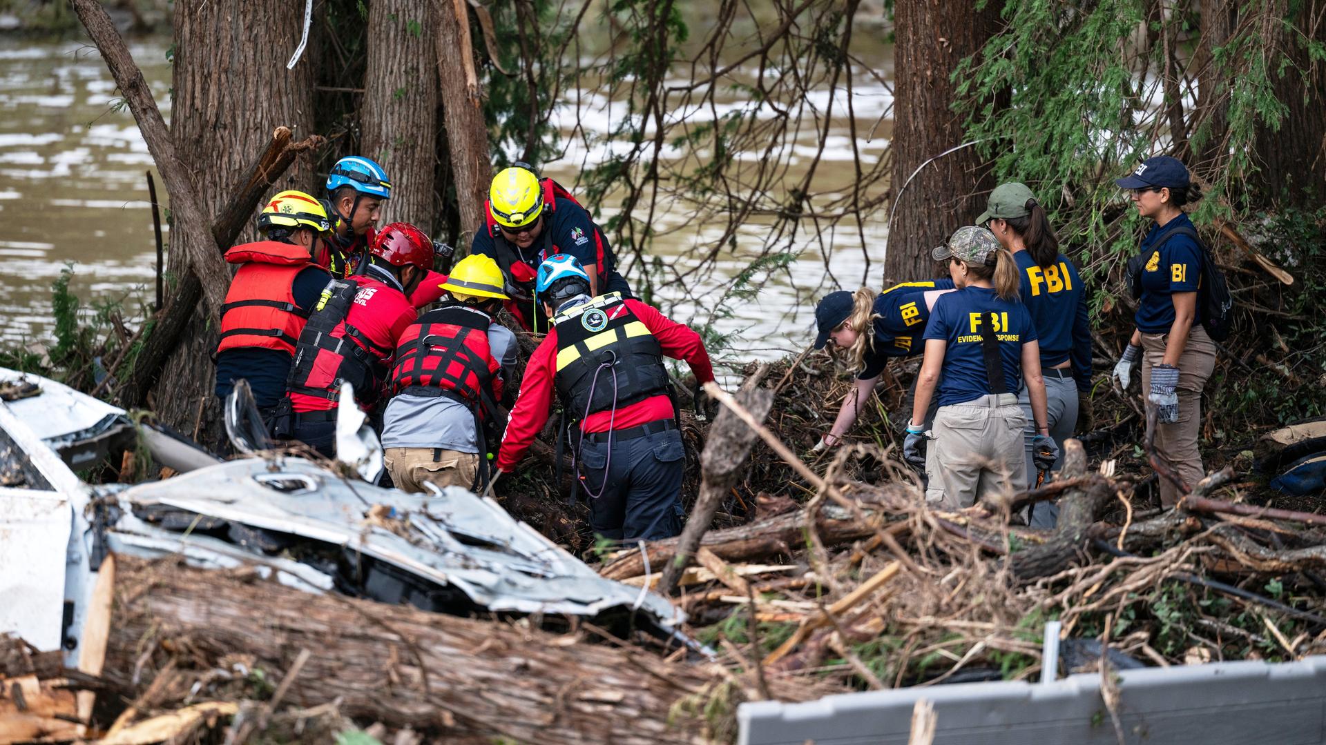 Feuerwehrleute und eine kleine Gruppe Freiwilliger arbeiten nach der Sturzflut am Guadalupe River. Feuerwehrleute und eine kleine Gruppe Freiwilliger arbeiten nach der Sturzflut am Guadalupe River.