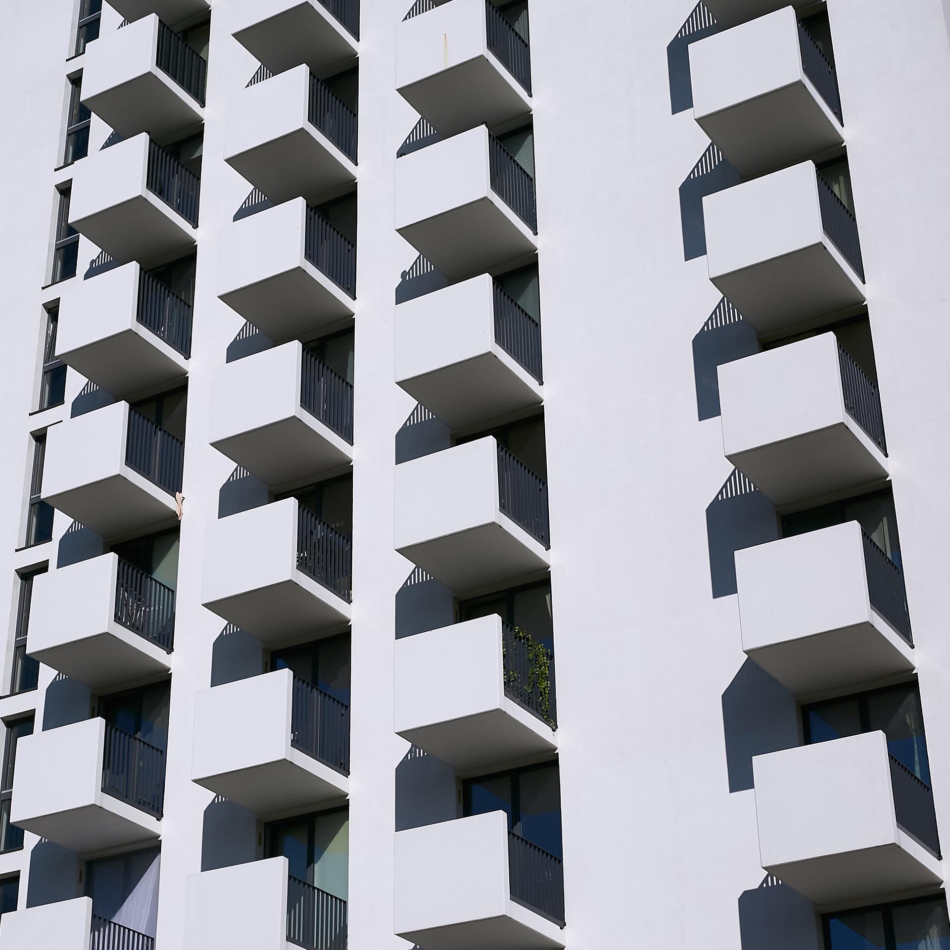 Neubau eines Hochhauses mit kleinen Appartements in Berlin-Lichtenberg. Die vielen kleinen Balkone prägen die weiße Fassade des Gebäudes.