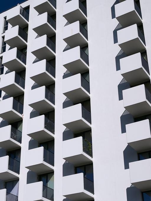 Neubau eines Hochhauses mit kleinen Appartements in Berlin-Lichtenberg. Die vielen kleinen Balkone prägen die weiße Fassade des Gebäudes.