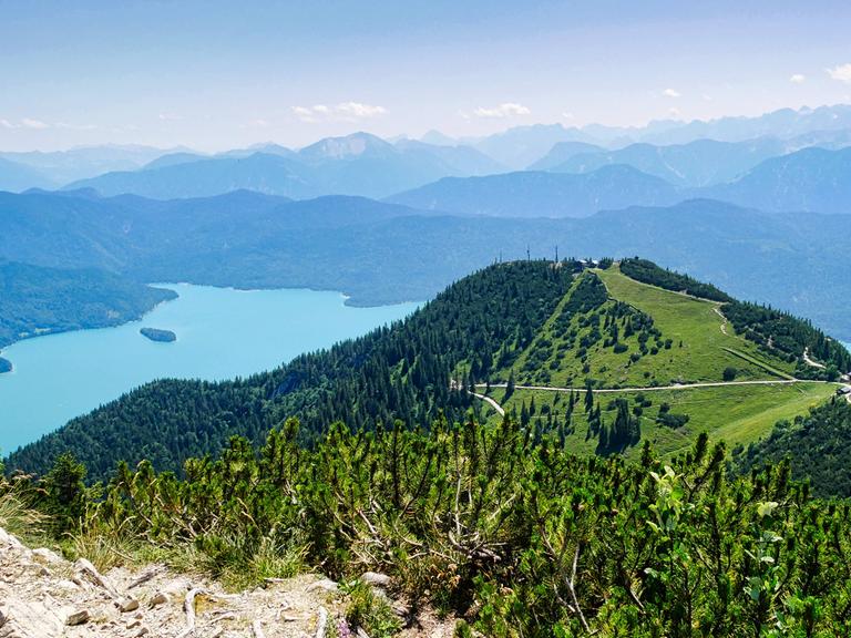 Weiter Panoramablick vom Berg auf eine alpine Seenlandschaft