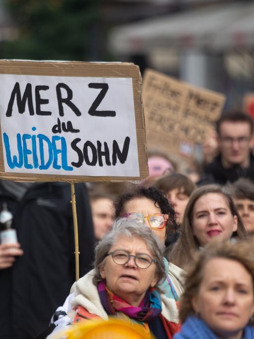 Proteste gegen Bundeskanzler Friedrich Merz und seine Stadtbild-Äußerung: Auf einer Demo wird ein Schild mit der Aufschrift "Merz du Weidelsohn" hochgehalten.