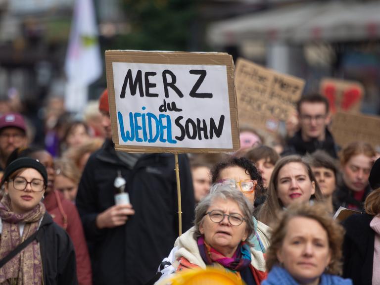 Proteste gegen Bundeskanzler Friedrich Merz und seine Stadtbild-Äußerung: Auf einer Demo wird ein Schild mit der Aufschrift "Merz du Weidelsohn" hochgehalten.